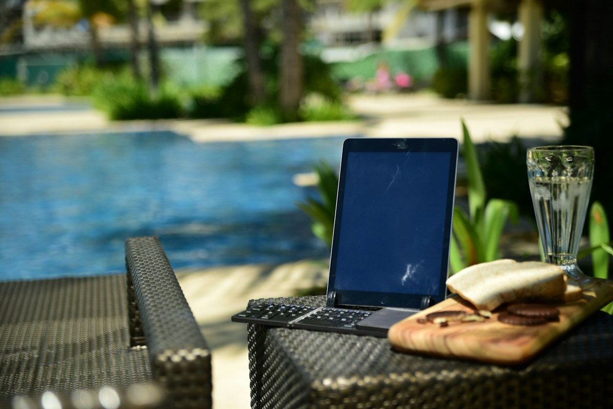 A laptop computer sitting on top of a table next to a pool in the Philippines