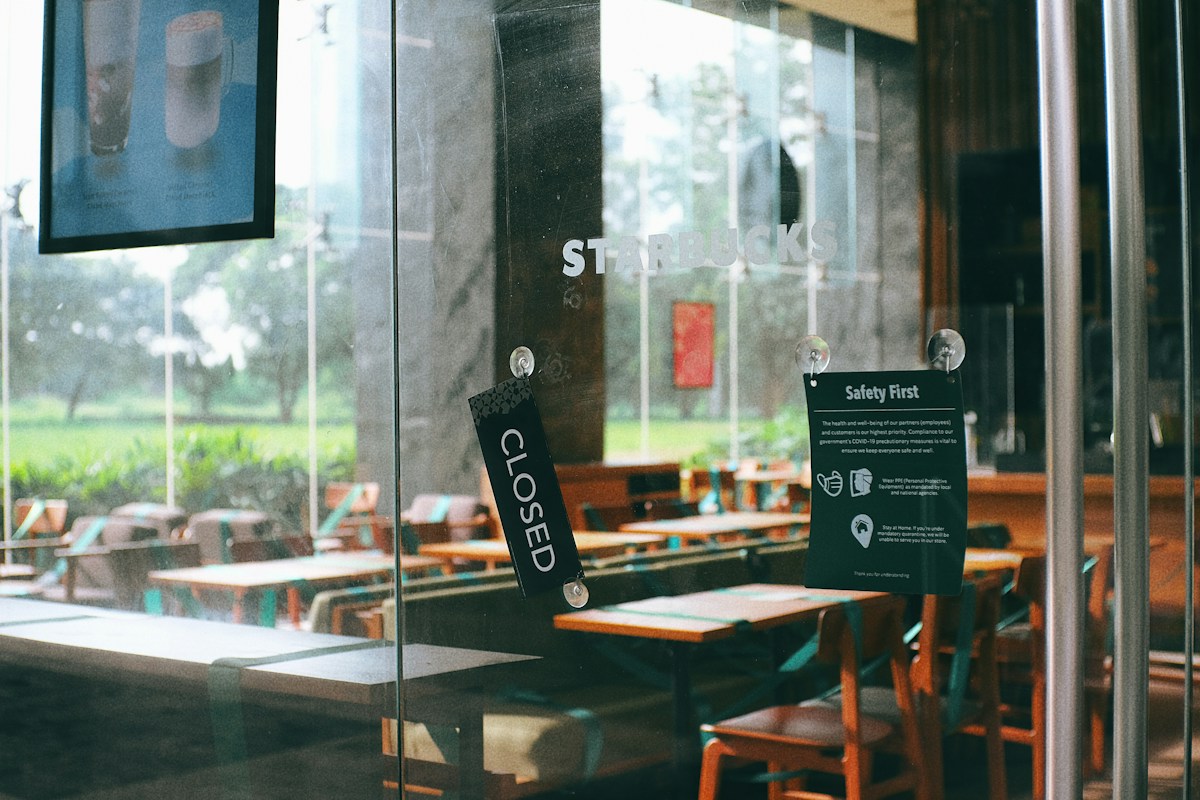 A restaurant with tables and chairs and a sign on the glass in the Philippines